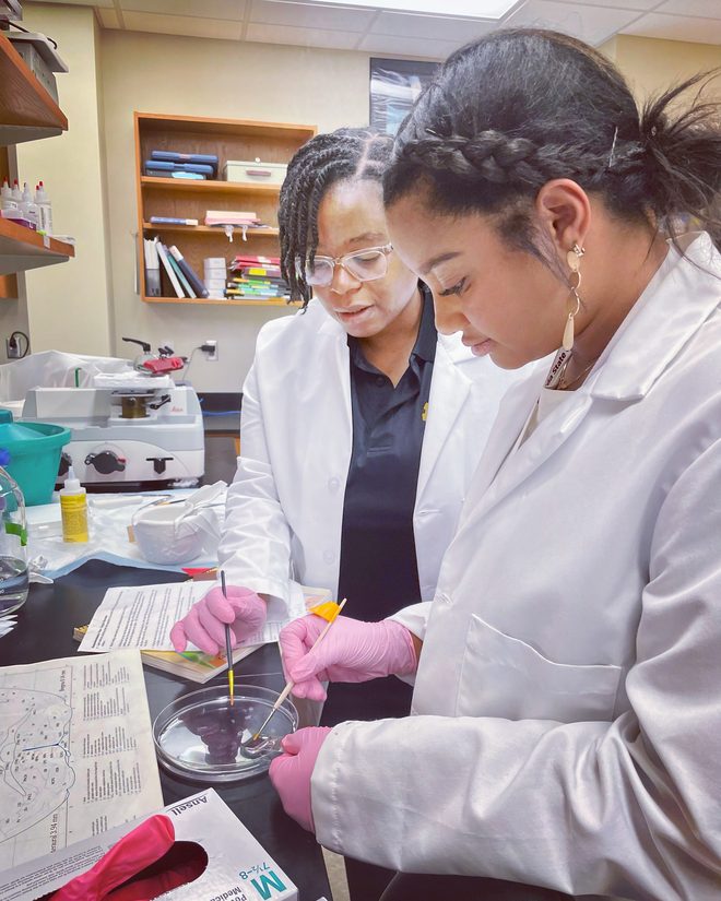 Dr. Delva mentoring a student during a lab dissection